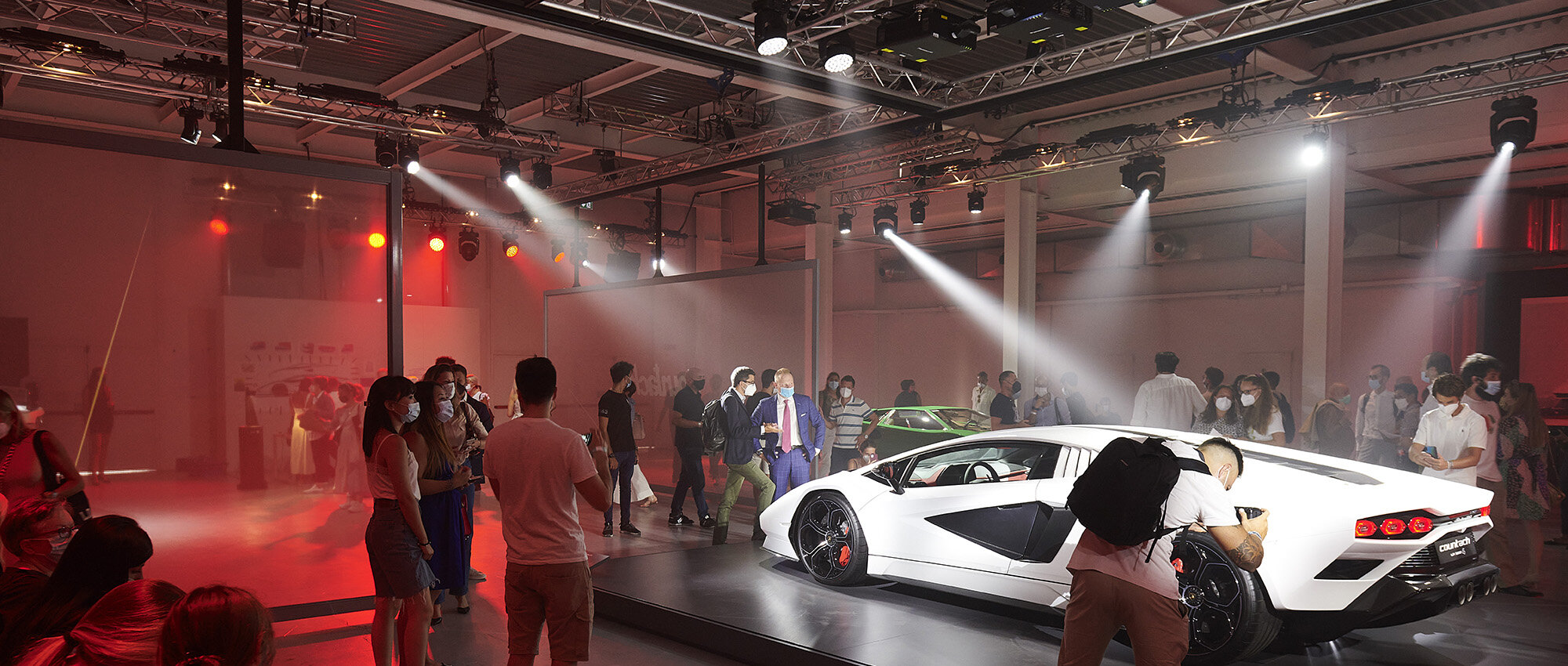 Event Production — light beams and rigging cutting through haze over a launch floor