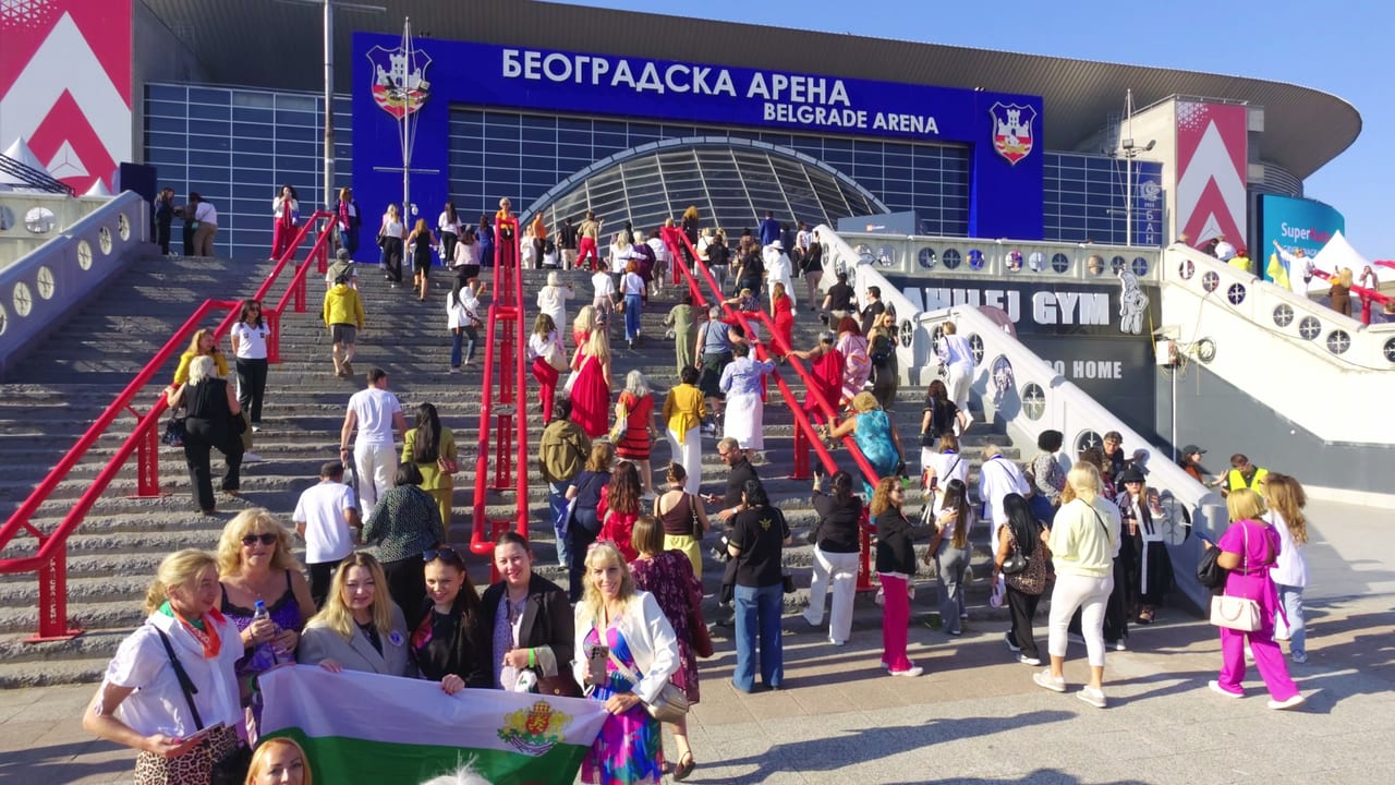 Global Convention attendees arriving up the steps of Belgrade Arena on a sunny day, waving flags
